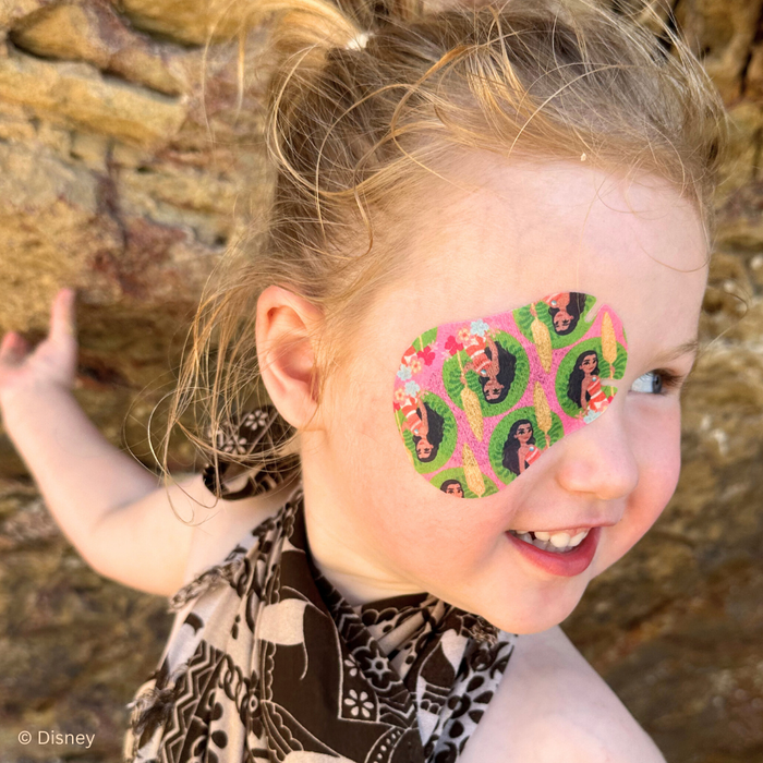 Girl by coastal rocks wearing a Disney Moana eye patch