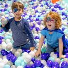 Two children in a ball pit wearing Disney and Pixar Elio eye patches