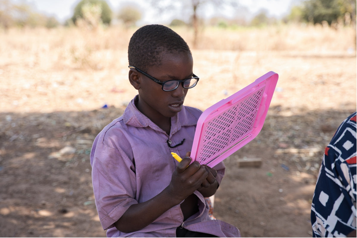 A child wearing glasses and reading