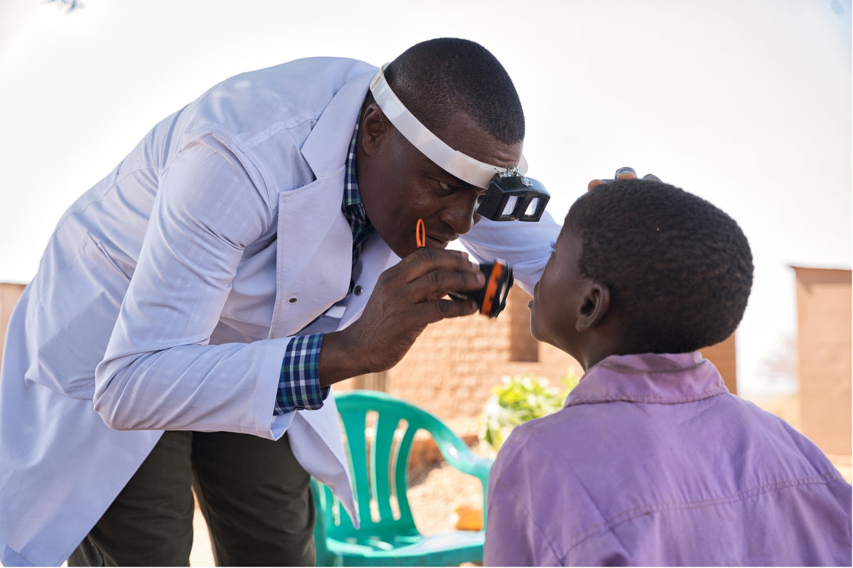 An eye care professional examining a child’s eyes
