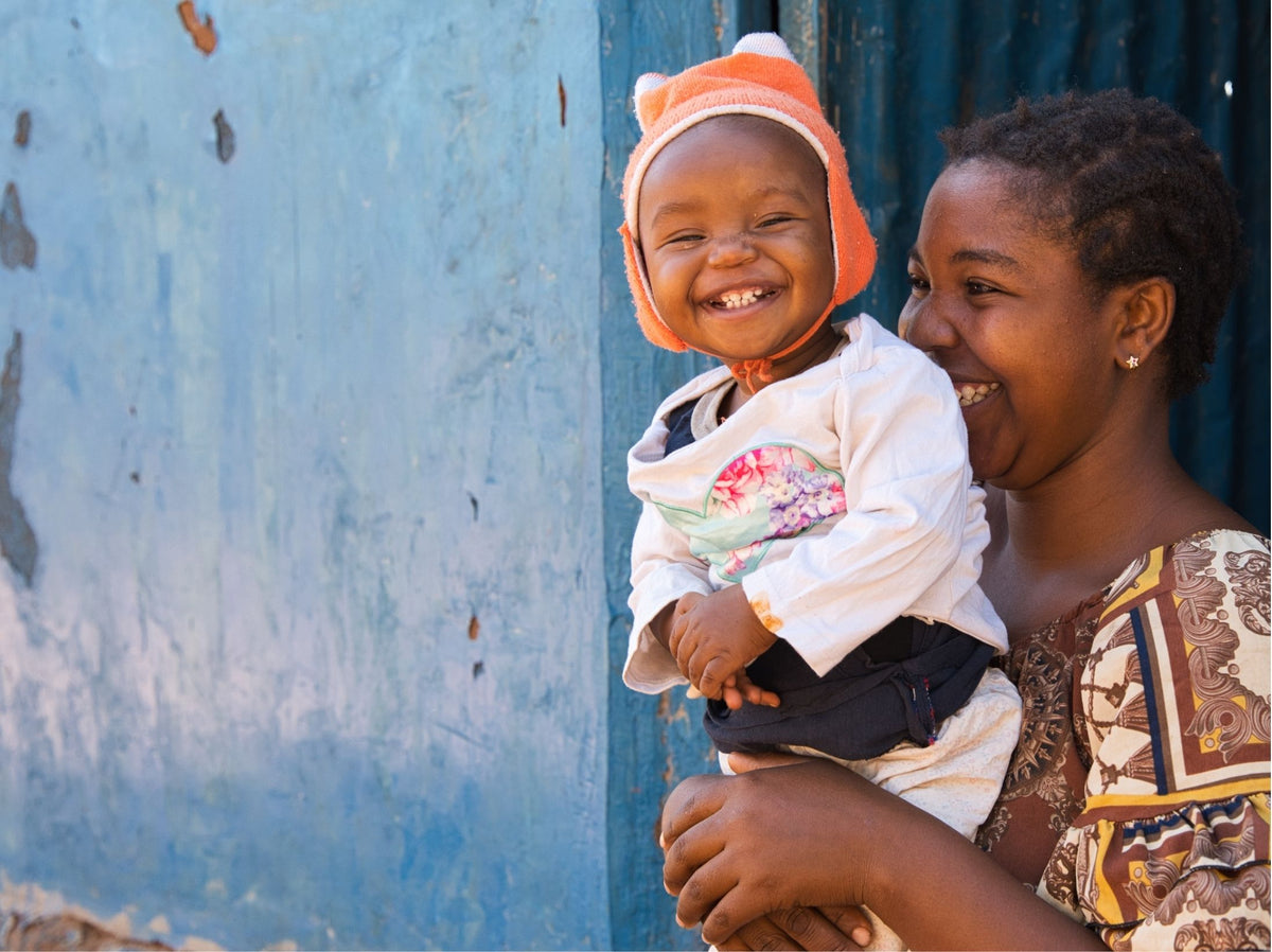 A smiling child with their mother